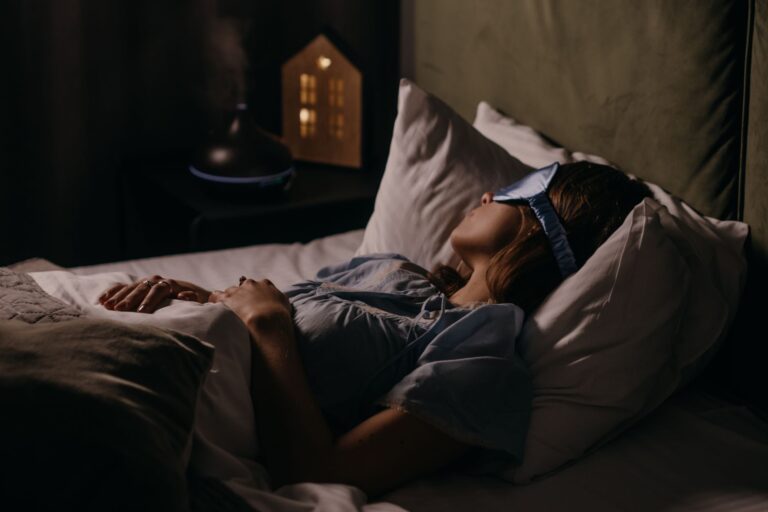 A woman peacefully sleeping with an eye mask in a dimly lit bedroom, capturing a serene bedtime atmosphere.