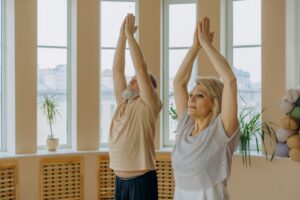 Senior couple practicing yoga poses indoors, promoting wellness and mindfulness.