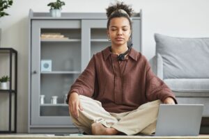 A serene woman practicing meditation at home, promoting relaxation and wellness.